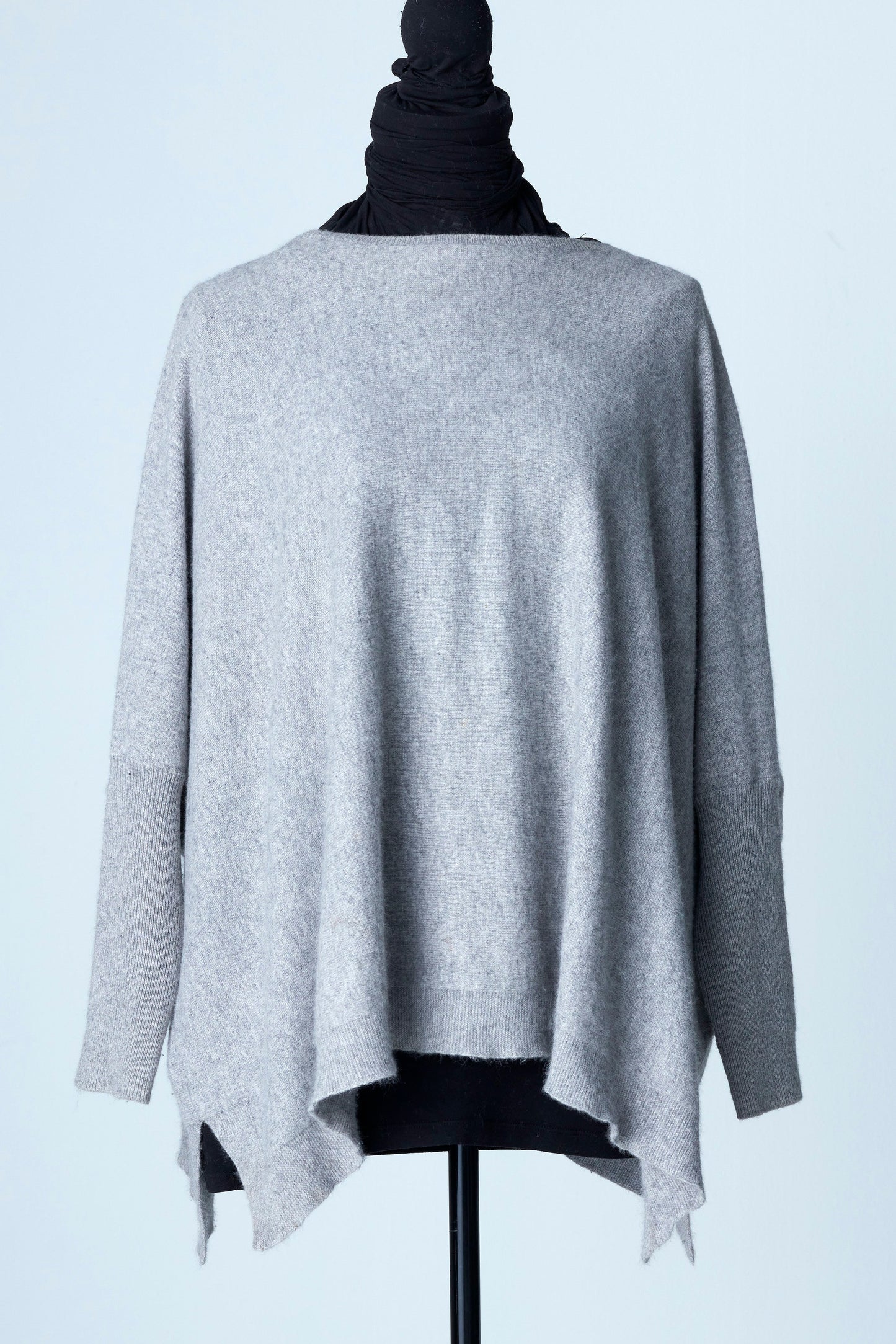 Vår Cashmere Poncho Sweater med Vid Midja och Tight Arm är den ultimata kombinationen av komfort och elegans. Tillgänglig i tre underbara färger - Sky Blue, Taupe och Light Grey som på denna bild - denna poncho sweater är ett måste för alla modeentusiaster.