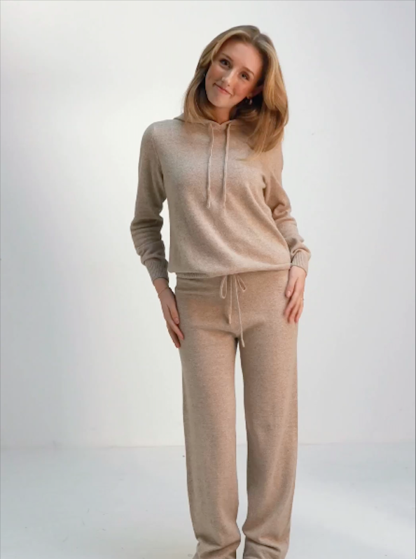 Utforska vårt exklusiva och mysiga Cashmere lounge wear set i eleganta färgerna mörkgrå och sandfärg - den ultimata kombinationen av komfort och stil. Detta underbara set inkluderar en mjuk byxa och en varm hoodie, noggrant utformade för att erbjuda dig en känsla av lyx och avslappning.