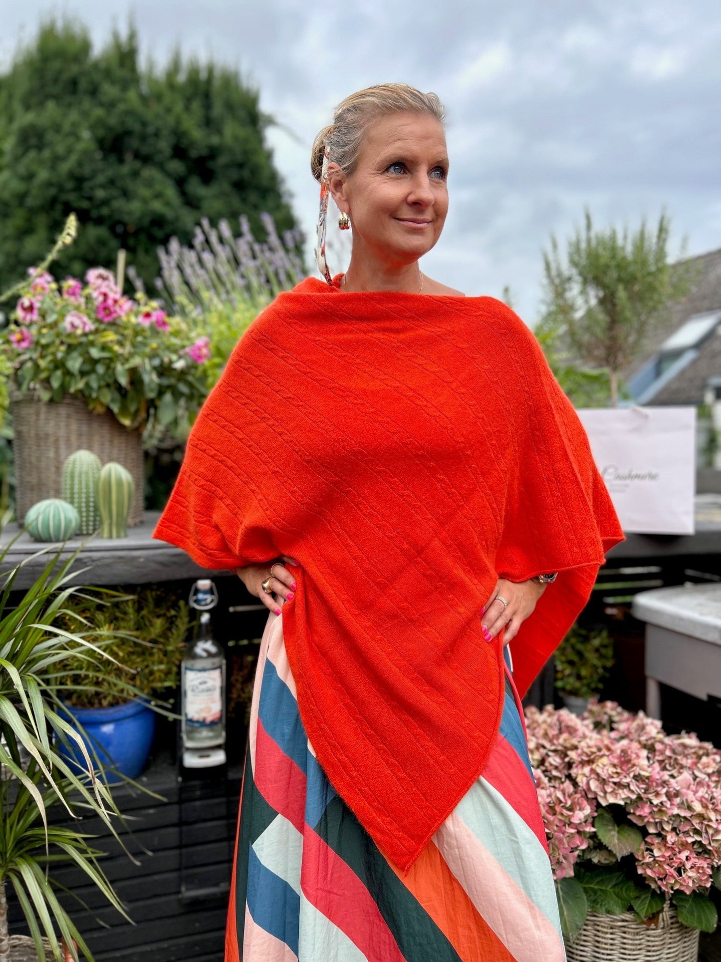 Cashmere poncho med kabelmönster i färgen Orange - en harmonisk förening av elegans och komfort. Det vackra kabelmönstret ger den en tidlös charm och en subtil textur som utstrålar klass och sofistikation. Denna poncho är skapad med precision för att ge dig den ultimata kombinationen av stil och mjukhet. Kabelmönstret ger den en extra dimension av textur och stil som skapar en tidlös och klassisk look.