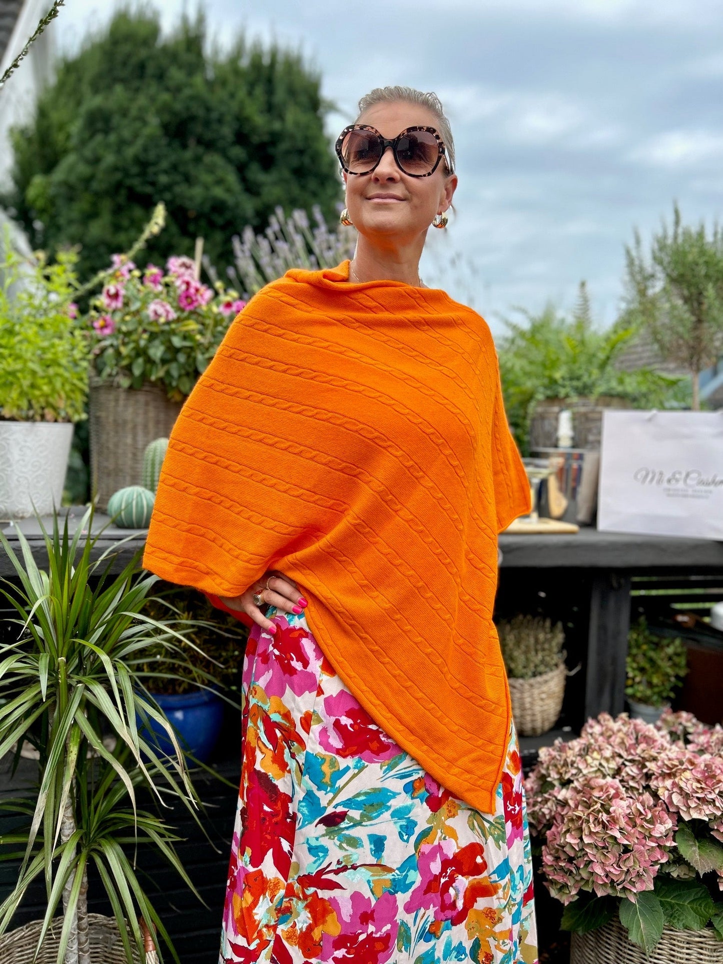 Cashmere poncho med kabelmönster i färgen Apelsin Orange - en harmonisk förening av elegans och komfort. Det vackra kabelmönstret ger den en tidlös charm och en subtil textur som utstrålar klass och sofistikation. Denna poncho är skapad med precision för att ge dig den ultimata kombinationen av stil och mjukhet. Kabelmönstret ger den en extra dimension av textur och stil som skapar en tidlös och klassisk look.
