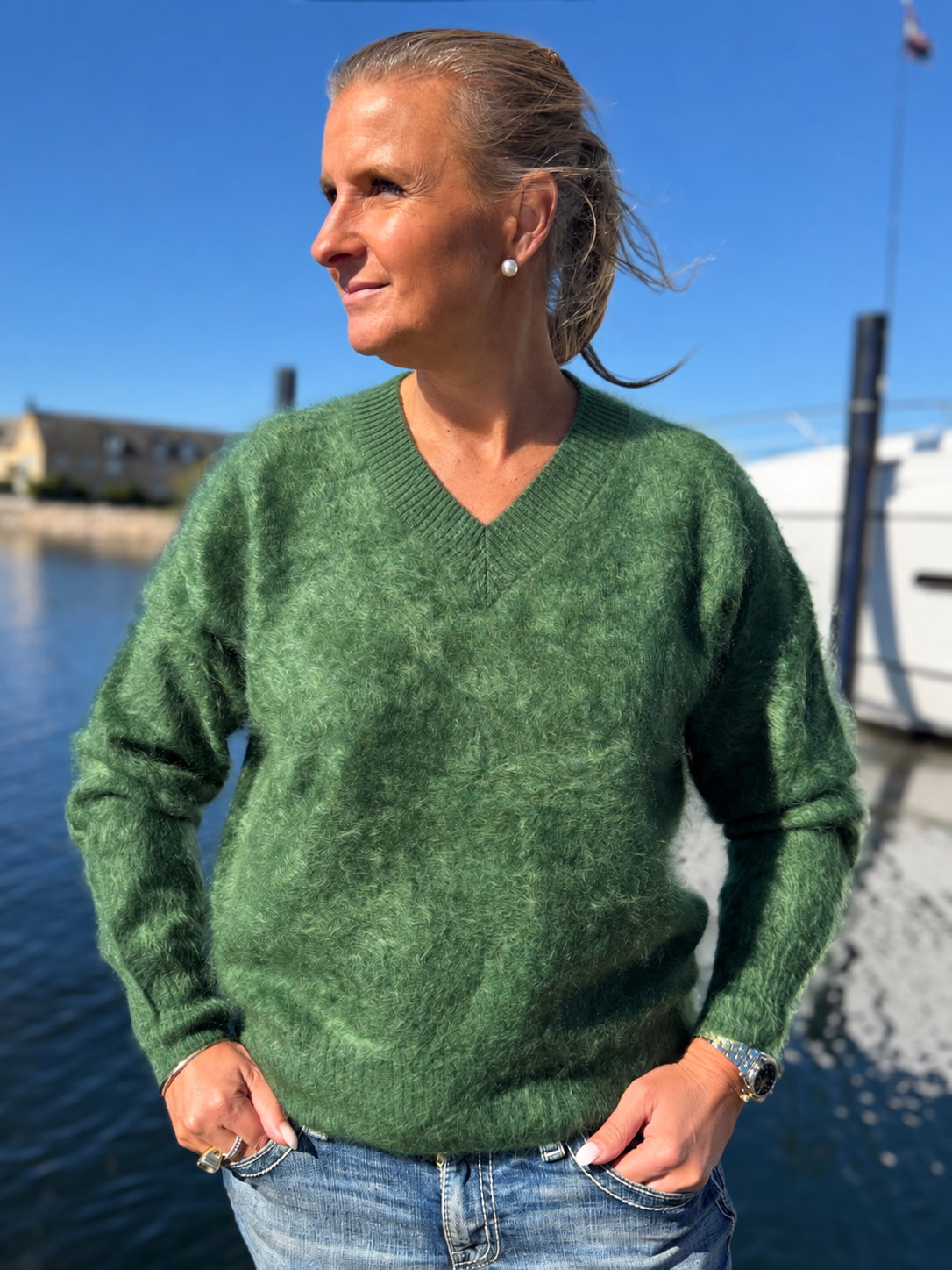 Kvinna i grön borstad cashmeretröja med V-ringning