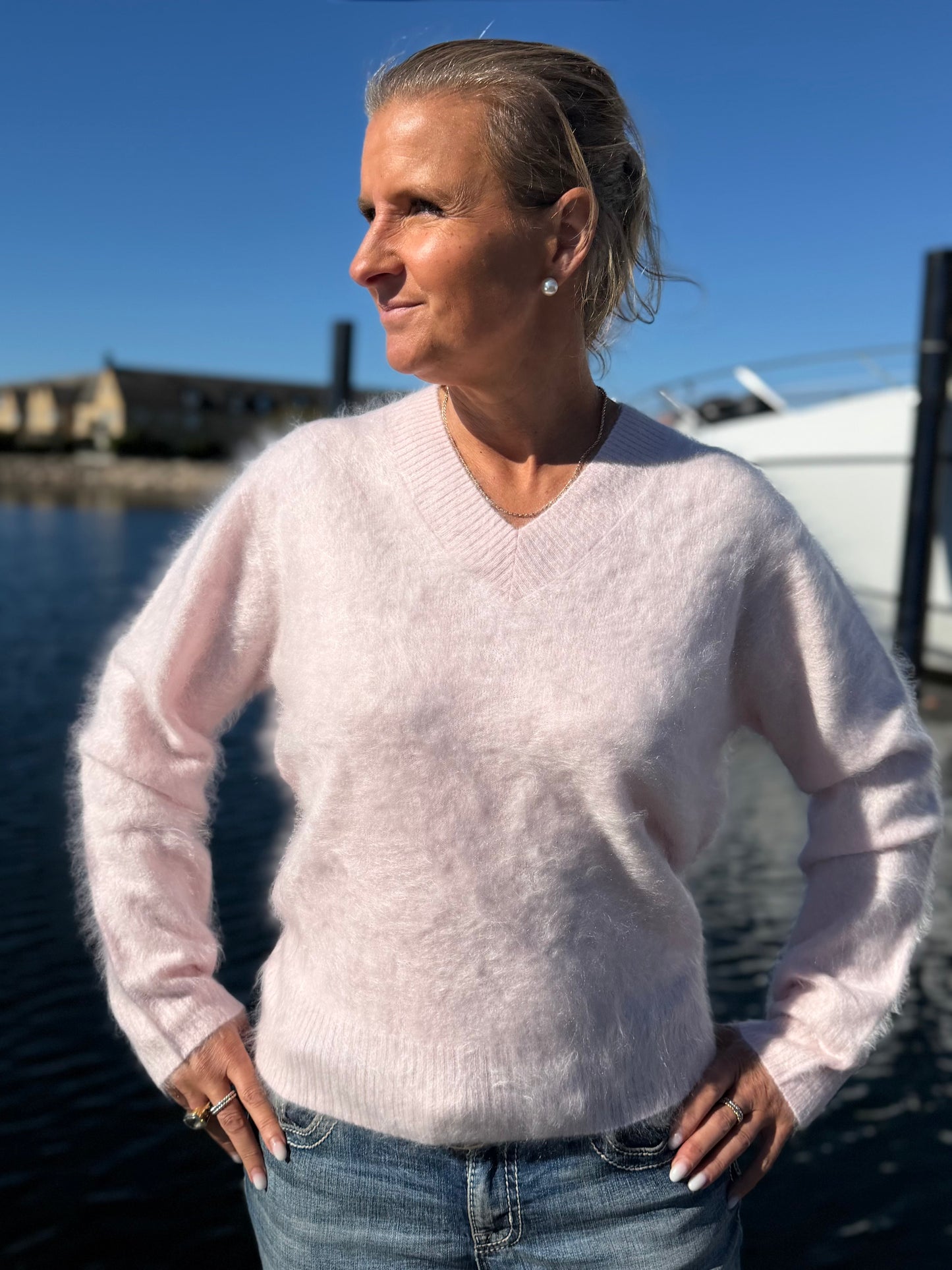 Kvinna i ljusrosa borstad cashmeretröja med V-ringning