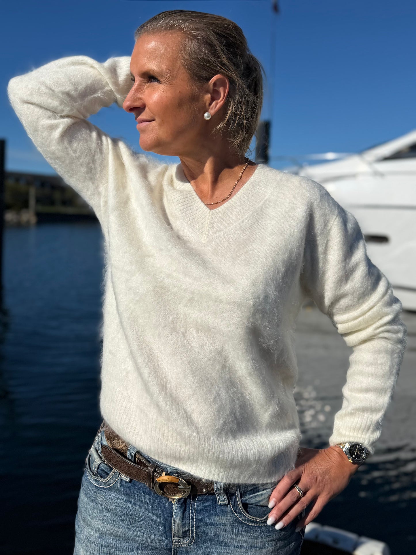 Kvinna i offwhite borstad cashmeretröja med V-ringning