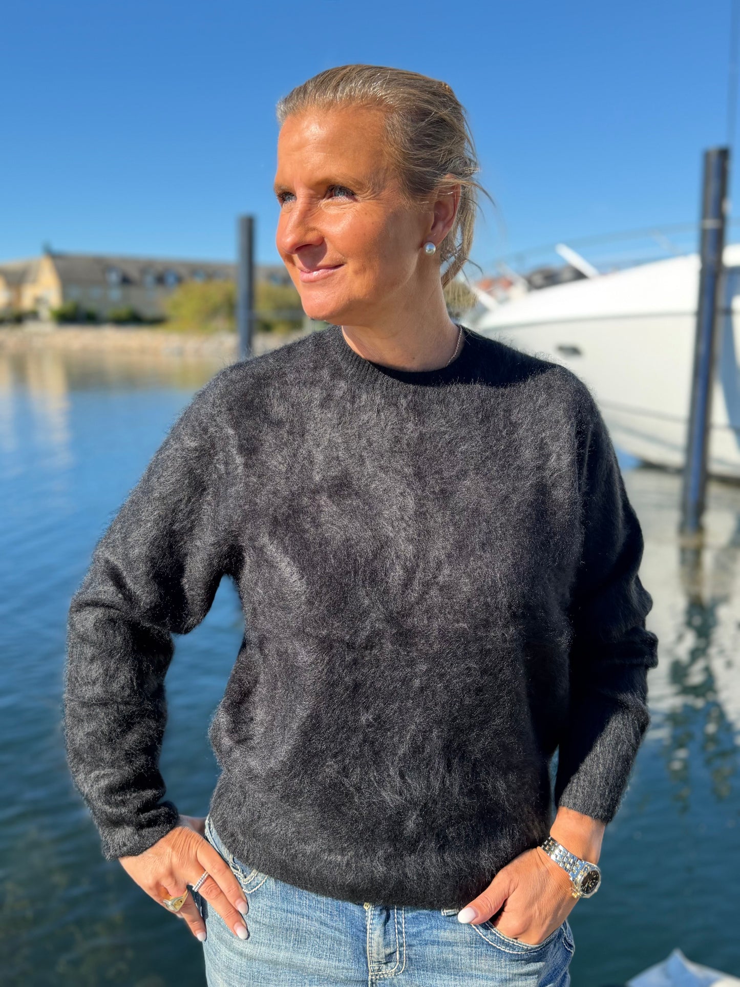 Kvinna i svart borstad cashmeretröja med rund hals