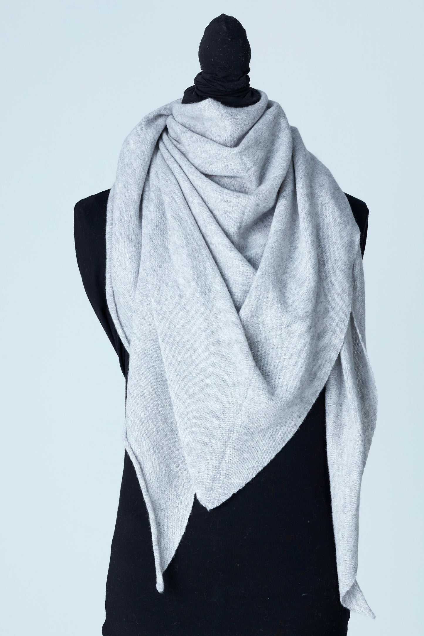 Vår Triangulära Cashmere Scarf i färgen light grey är inte bara en accessoar för att hålla dig varm, den är en stilfull deklaration av din personliga smak. Med en triangulär form erbjuder denna scarf ett unikt sätt att sätta färg och elegans på ditt utseende.
